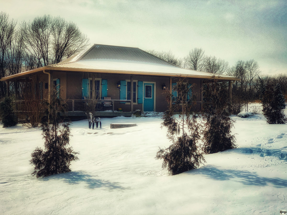  French Creole Cabin in the snow with blue hurricane shutters