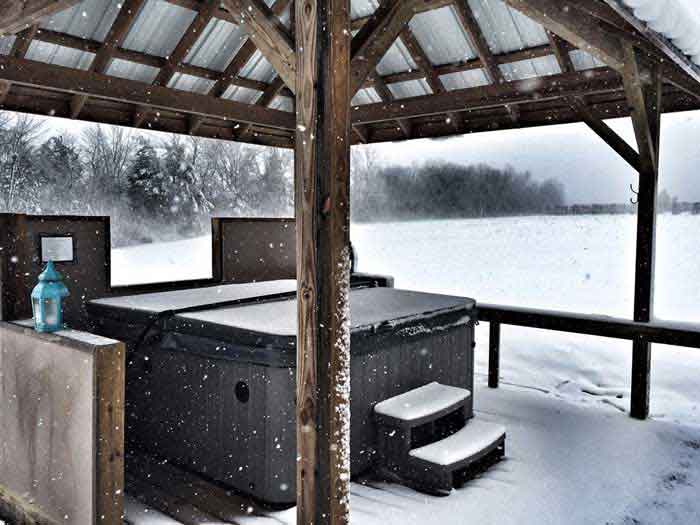 Snow covered hot tub pavilion at The Creole Cabin