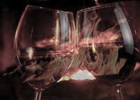 Clinking wine glasses in front of fireplace