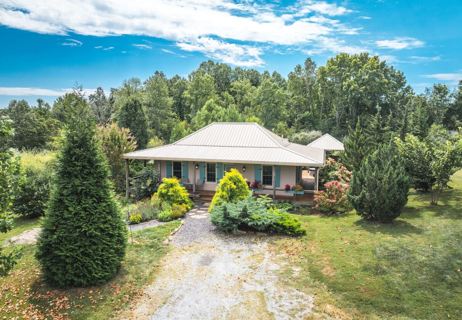 Drone view of the French Creole Cabin showing lush landscaping and surrounded by the forest.