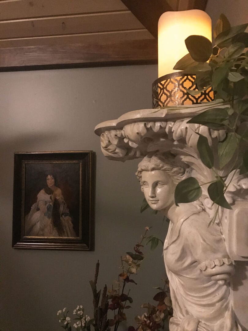 Classical wall sculpture and candle accent adding French-inspired elegance to the French Cabin interior.